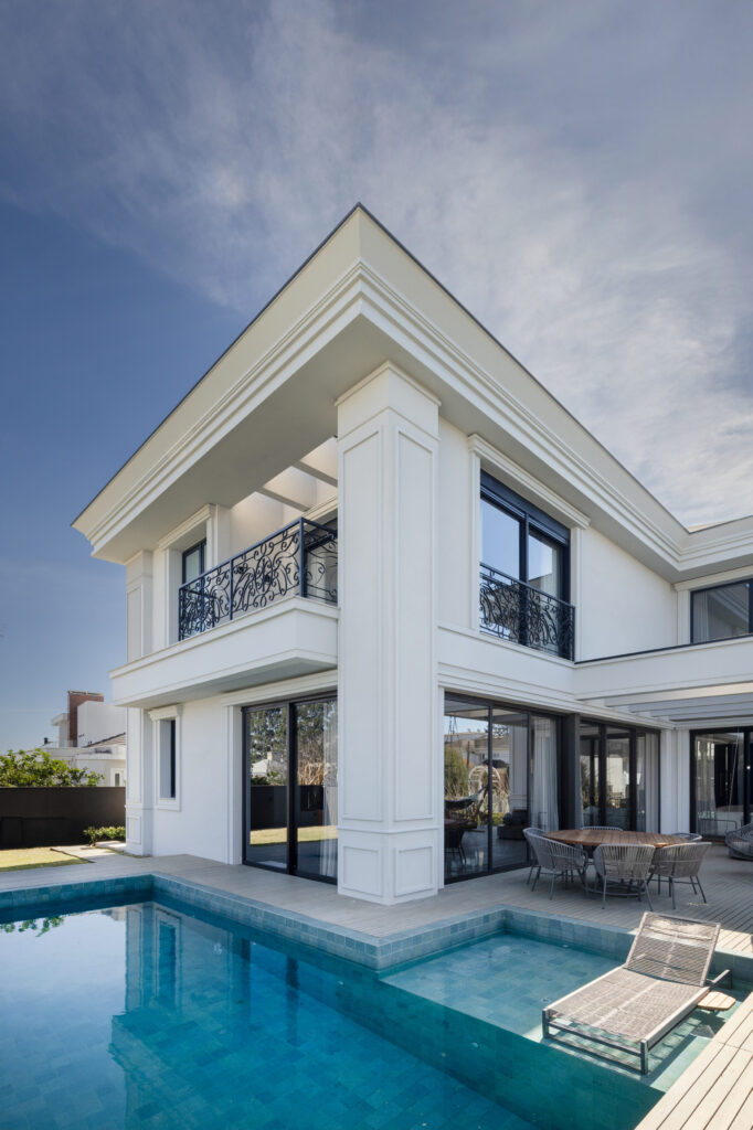 Fachada dos fundos com varanda, piscina e esquadrias de vidro de correr Weiku
