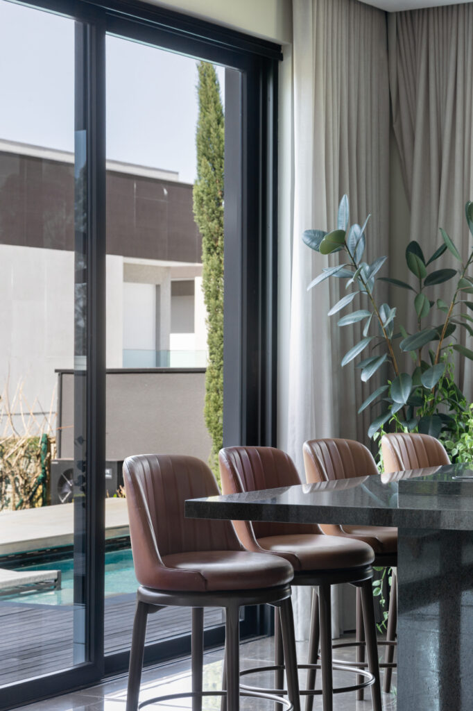 Sala de jantar com porta de vidro de correr Weiku voltada para a área de piscina