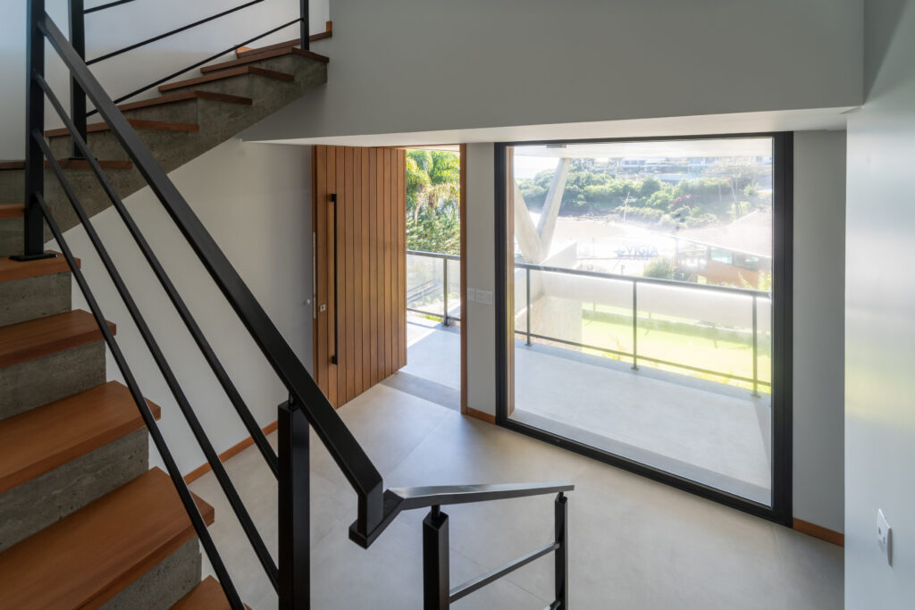 Escada com grande esquadria de vidro fixa Weiku emoldurando a paisagem