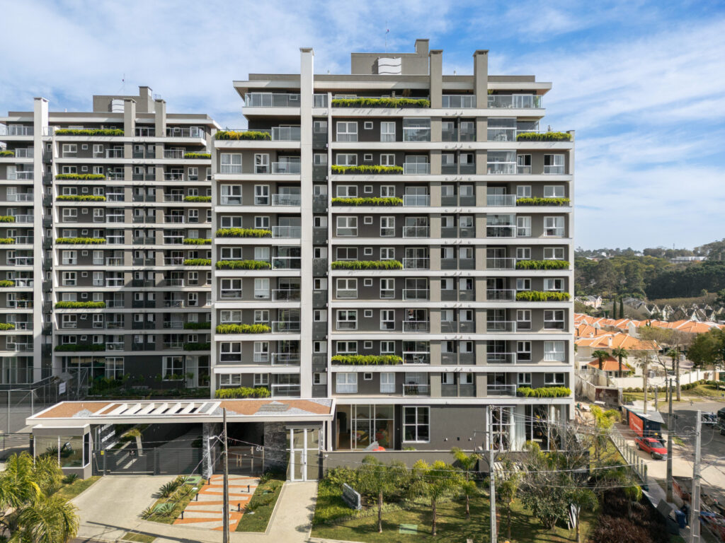 Fachada do Edifício Trebbiano em Curitiba, com sacadas verdes, portaria e esquadrias de vidro Weiku