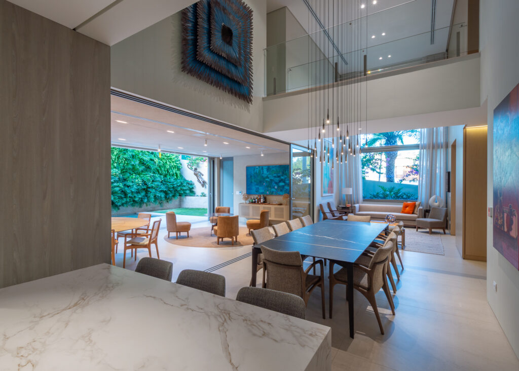 Living e sala de jantar de pé-direito duplo com portas de vidro de correr Weiku abertas para a varanda e o jardim vertical