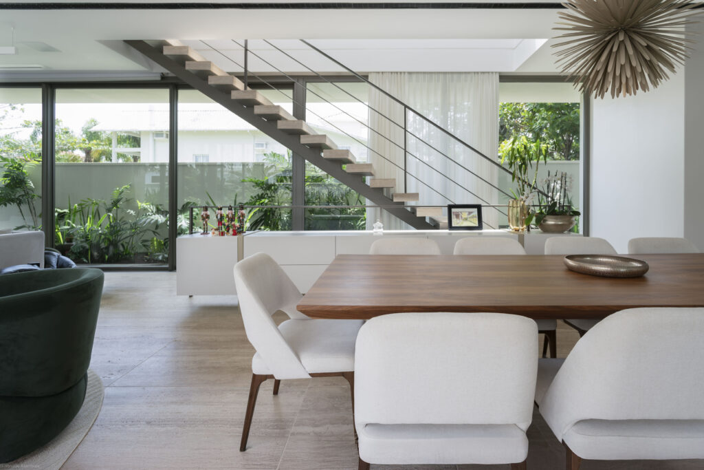 Sala de jantar com escada vazada e pano de vidro Weiku do piso ao teto voltado para o jardim