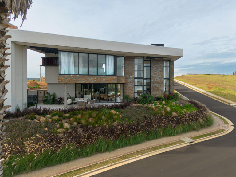Fachada de esquina de residência contemporânea em pedra natural, com panos de vidro Weiku de perfil preto e jardim paisagístico
