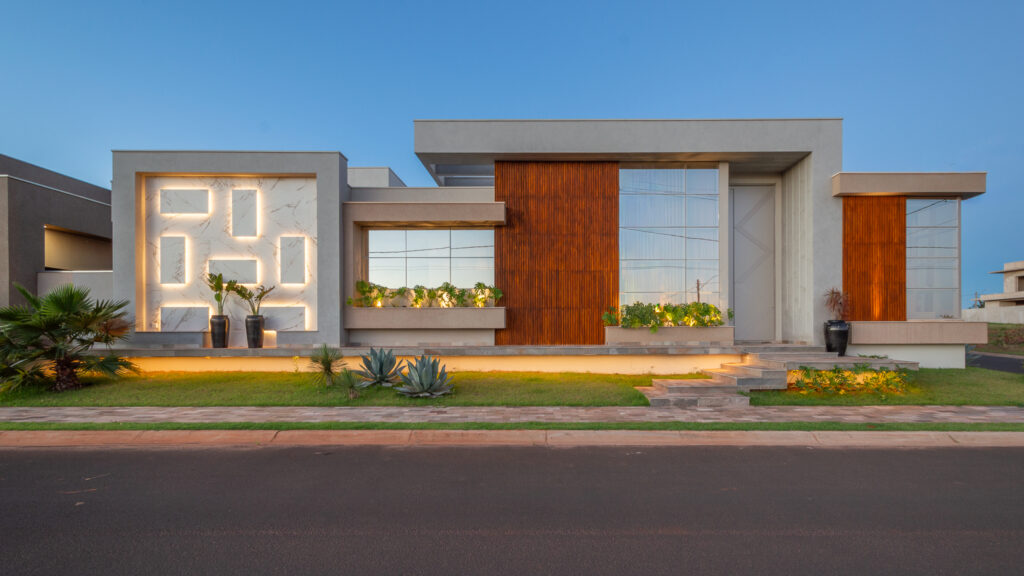 Fachada de residência térrea contemporânea com painel de mármore iluminado, painéis ripados de madeira e panos de vidro Weiku